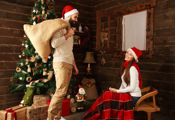 Young couple in holiday home in Christmas presents gifts