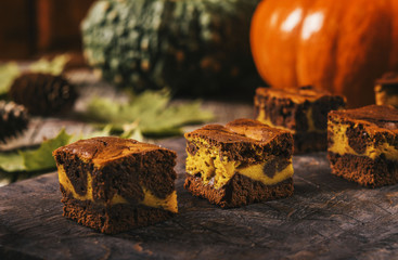 Pumpkin chocolate brownie on a dark wooden background. Baking for Thanksgiving Day. Selective focus. Toned image 