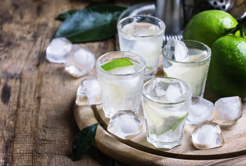 Bitter cocktail with lime, green grapefruit, ice and gin. Dark b