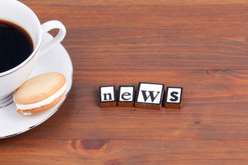 Coffee cup on a wooden table and text - News