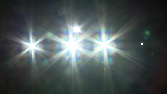 Theater spots shining into the camera, forming star shaped beams.