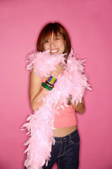 Young woman looking at camera, wearing feather boa