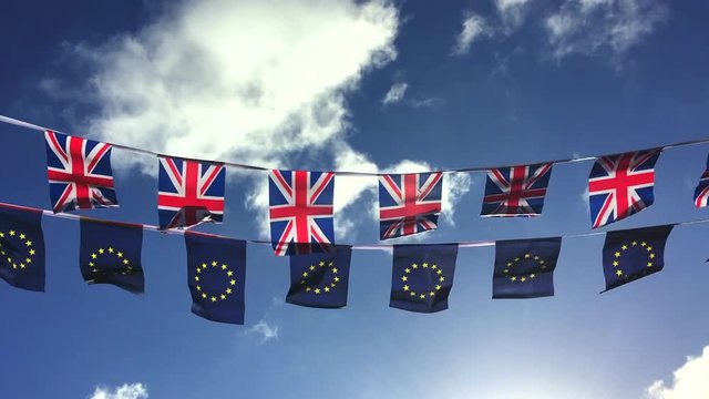 European Union and British Union Jack flag bunting flying in bright blue sky in a statement of the Brexit EU referendum