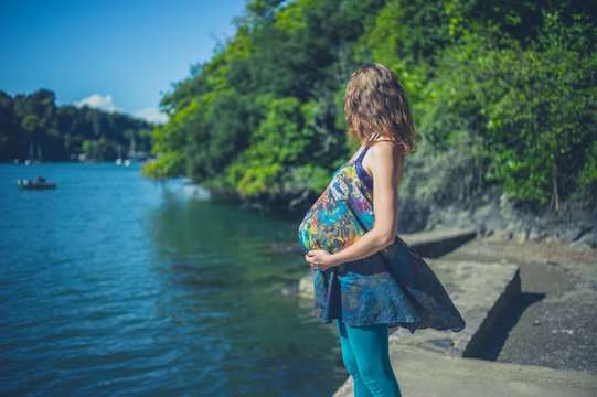 Pregnant woman by water in summer