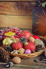 Christmas Composition with Gifts. Basket, red balls, pine cones, snowflakes on Wooden Table. Vintage style
