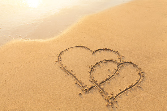 Two hearts drawn in the sand, symbol of love, honeymoon