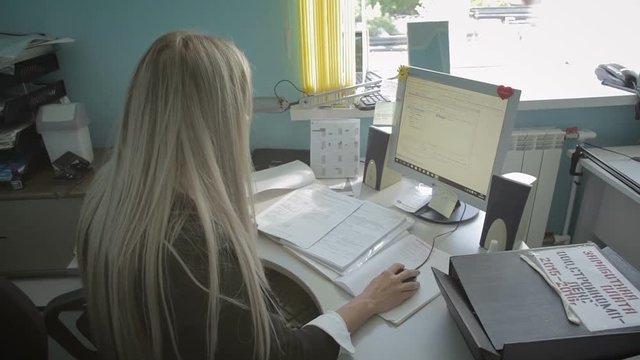 Beautiful young business woman working at computer in the office stock footage video