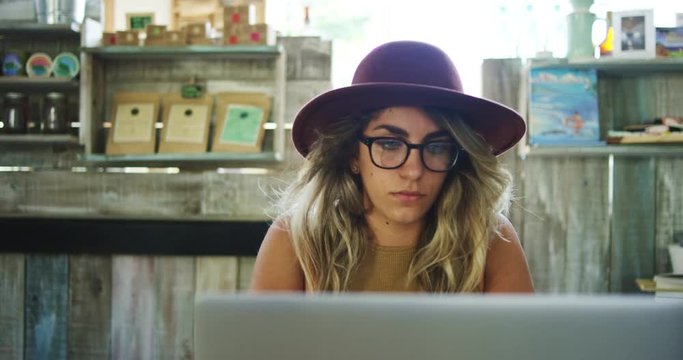 Woman using laptop computer in coffee shop, working in mobile office