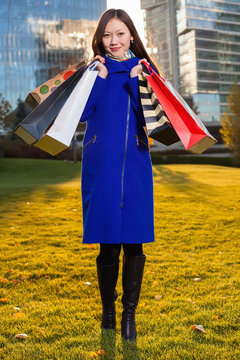 Two Asian woman holding shopping bags in hand