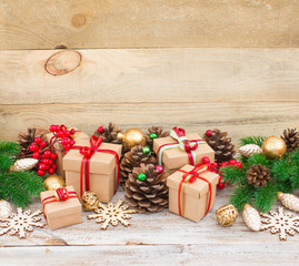 Fototapeta na wymiar Christmas or New Year background: gifts, colored glass balls, decoration and cones on wooden background