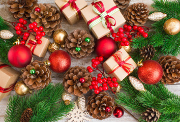 Christmas or New Year background: gifts, colored glass balls, decoration and cones on wooden background