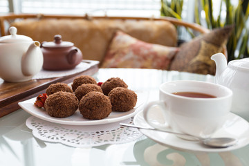 chocolate balls on the table with a cup of tea and teapot