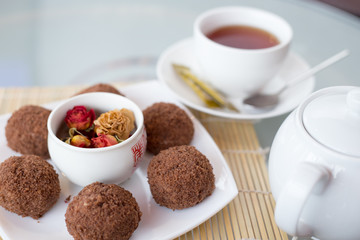 chocolate balls on the table with a cup of tea and teapot