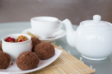 chocolate balls on the table with a cup of tea and teapot