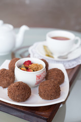 chocolate balls on the table with a cup of tea and teapot
