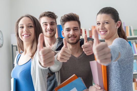 Cheerful students with thumbs up