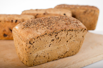 a loaf of bread on the background of cutting boards and other bread