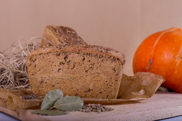 a loaf of bread on the background of cutting boards and other bread and pumpkin,