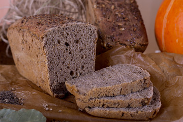 a loaf of bread on the background of cutting boards and other bread and pumpkin,