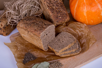 a loaf of bread on the background of cutting boards and other bread and pumpkin,