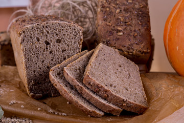 a loaf of bread on the background of cutting boards and other bread and pumpkin,