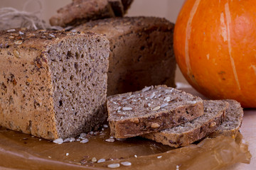 a loaf of bread on the background of cutting boards and other bread and pumpkin,