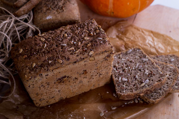 a loaf of bread on the background of cutting boards and other bread and pumpkin,