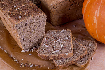 a loaf of bread on the background of cutting boards and other bread and pumpkin,