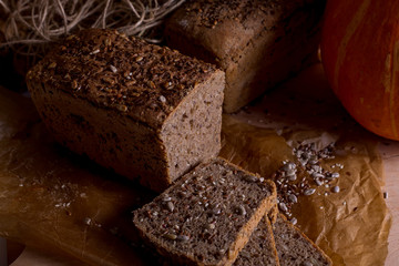a loaf of bread on the background of cutting boards and other bread and pumpkin,