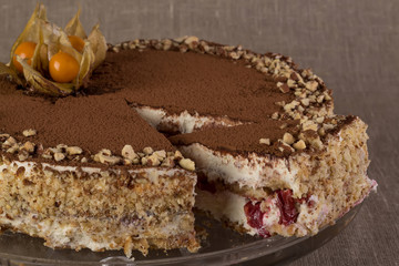 Tiramisu cake with berries on a background of burlap