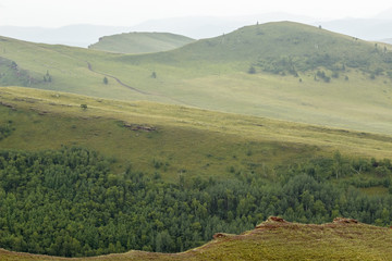 Obraz premium Russia. Khakassia. Western Sayan. Chests mountain range in fog. The hills and wooded grasslands. Locality - the cradle of the Khakass people. The remains an ancient culture.