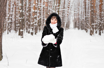 Fototapeta na wymiar young woman in fur coat outdoors in snow garden