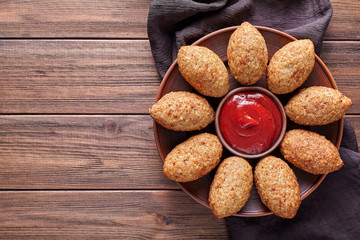Kibbeh traditional homemade arabic beef, lamb, goat or camel meat stuffed bulgur kofta spicy meatball fried croquettes dinner food on rustic wooden table background