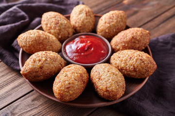 Kibbeh traditional homemade middle eastern beef, lamb, goat or camel meat stuffed bulgur kofta spicy meatball fried croquettes dinner food on rustic wooden table background