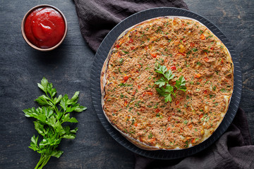 Lahmacun traditional turkish homemade pizza with minced beef or lamb meat, paprika, tomatoes, cumin...
