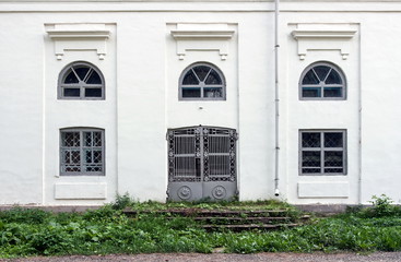 fragment of a facade of church with shod iron gate
