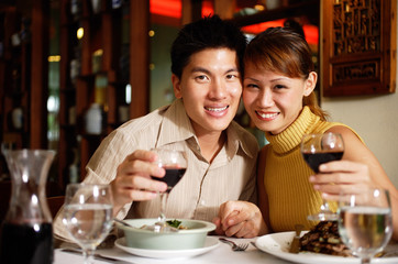 Couple in restaurant, smiling at camera