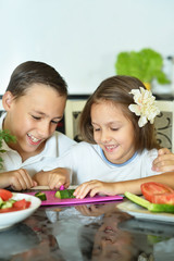 siblings preparing salad