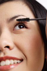 Woman applying mascara, close-up of face