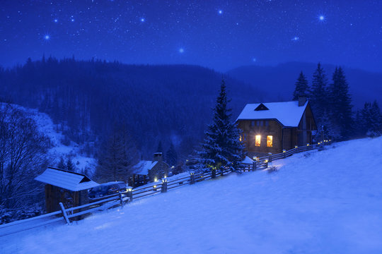 Fototapeta Winter landscape with a starry sky and mountain house