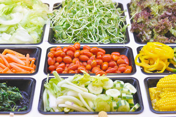 Various vegetables mixed on salad bar.