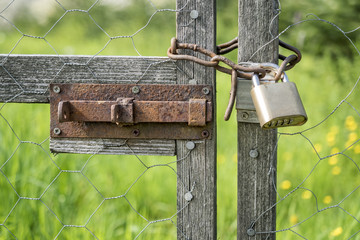 Wooden gate locked with padlock and chain