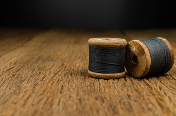 retro spool thread with pincushion on wooden board