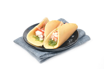 Pancakes with ham seaweed salad on gray napkin.