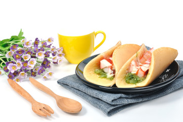 Fototapeta na wymiar Pancakes with ham seaweed salad on gray napkin with wooden table