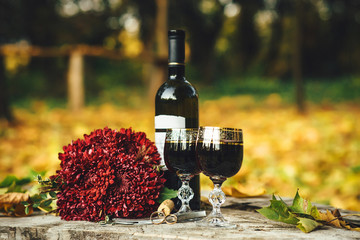 Wedding rings, glasses of wine, a bouquet of flowers on the wood