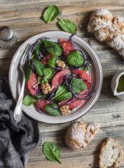 Fresh salad with grapefruit, spinach and red cabbage. On wooden background, top view.