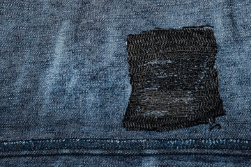Blue denim with a patch. Fabric grunge texture in high resolution - obrazy, fototapety, plakaty