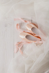 Obraz na płótnie Canvas Pink ballet pointe shoes and tutu on white wood background