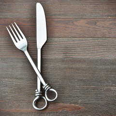Vintage kitchen utensils: fork and knife on wood rustic background. Menu background with copy space.